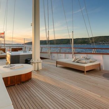 Die Besitzer eines Family Offices verfügen über eine Luxussegelyacht, deren Oberdeck mit Lounge-Bereich und Panoramablick auf das Meer, ausgestattet mit hochwertigen Holzdielen, einen idealen Ort für geselliges Beisammensein mit der Familie bietet.